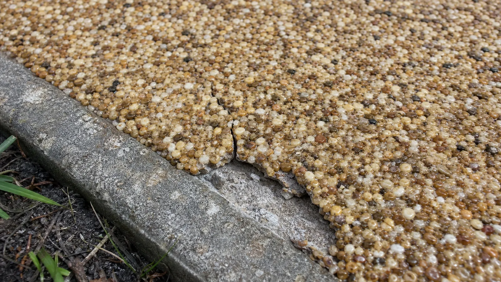 Cracked and failing resin bound driveway edge showing common installation faults